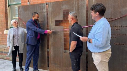 Bishop Saju, cuts the ribbon alongside the Vicar of Holy Trinity Church, Elaine Sutherland, and Alistair Hudson, the former CEO of East Midlands Sexual Health formerly known as LASS.   