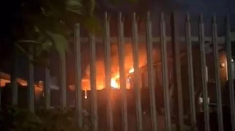 A fire at mixed use units seen through railings