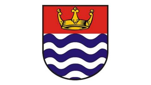 Coat of arms showing a golden crown behind a red background, and blue and white waves below.
