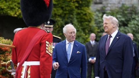 King Charles III (centre) and US President Donald Trump (right) meet military personal after a Beating Retreat military ceremony at Windsor Castle, Berkshire,