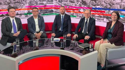 Jake Austin, Andy Burnham, Robert Kenyon, Michael Winstanley and Sarah Wakefield sit on a sofa before a BBC debate