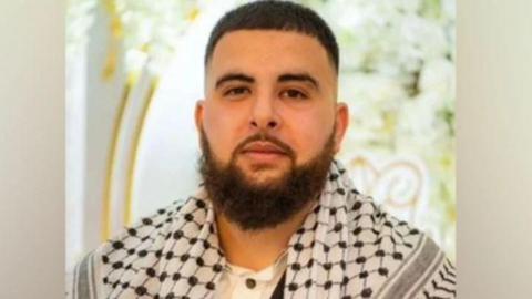 A family photograph of Raad Asmael with a beard and wearing a scarf