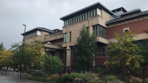 A view of Sheffield Crown Court, a red-bricked building with stone.
