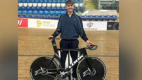 Lewis stood on the Derby Arena velodrome track with his racing bike.