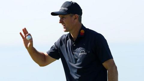 Justin Rose picks up his ball