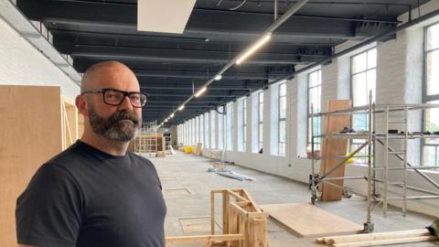 Museum director Joe Brook standing in the new space