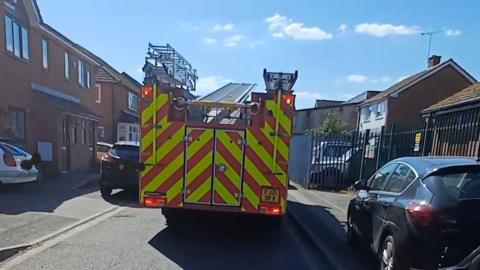 A photograph of the back of a fire engine with cars either side of it