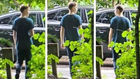 Three portrait shaped CCTV images of a young man with red hair in a blue t-shirt with his back to camera standing in front of a hedge with a car in front of him 