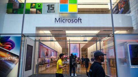 People walk past a Microsoft store in New York