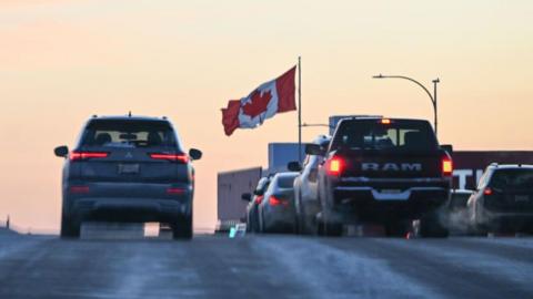 Cars on a highway with a Canadian flag