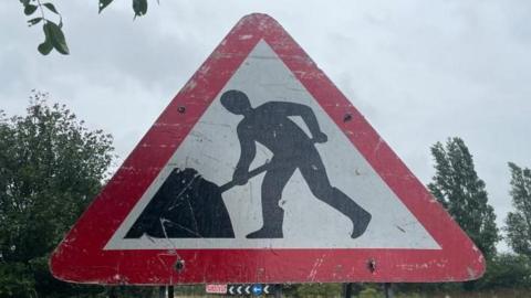 Stock image of a roadworks sign in a red triangle.