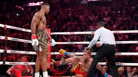 Anthony Joshua stands over Jake Paul on the canvas