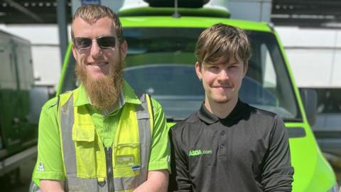 Two male ASDA delivery drivers leaning on the hood of a green delivery van and smiling at the camera. Allan, on the left, is wearing sunglasses and a bright green t-shirt underneath a yellow hi-vis vest. He has light brown hair and a long beard. The man on the right has dark brown hair, faint facial hair and is wearing a black branded ASDA polo shirt.