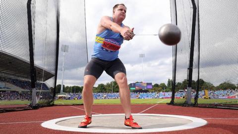 Jake Norris stands inside a throwing circle at the 2025 UK Athletics Championships in Birmingham, preparing to turn and then release the hammer into the infield sector