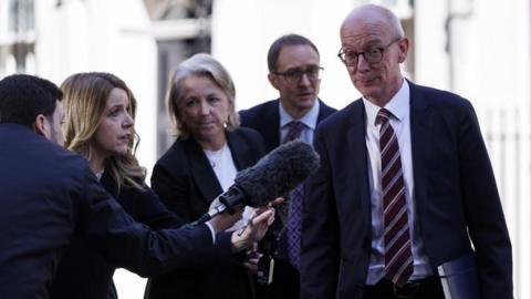 Britain's Secretary of State for Work and Pensions Pat McFadden (R) speaks to members 