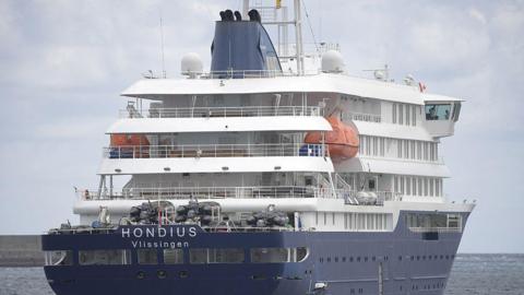 Large blue and white cruise ship with the words Hondius Vlissingen on it 