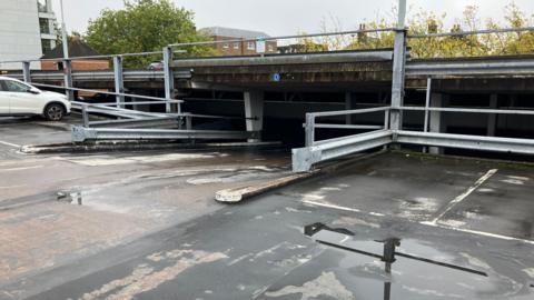 The top floor of the High Street Car Park, with a ramp going down into the lower levels. There is one car to the far left of the photograph.