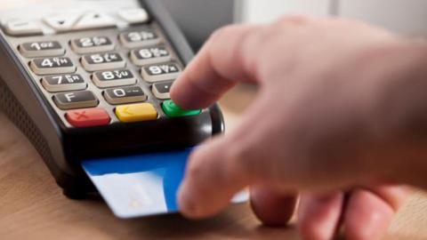 A person using a car machine with their bank card