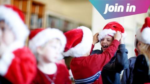 Children dressed up in Santa hats at school.
