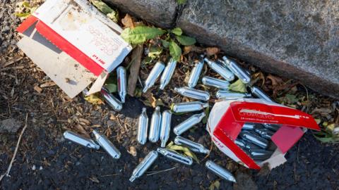 Nitruous oxide canisters on the pavement