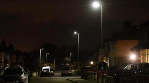 A darkened suburban street in Shipley with five of the LED street lights shining onto the road.