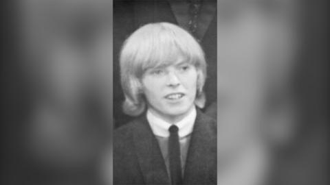 David Bowie in 1964 wearing a suit and tie