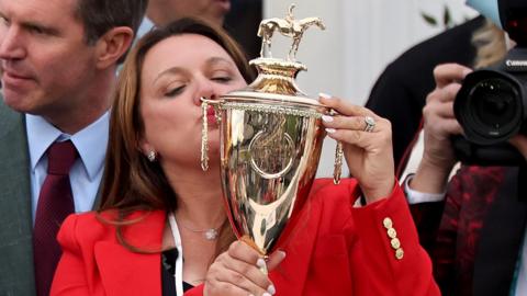 Cherie DeVaux kisses the Kentucky Derby trophy