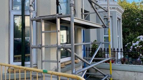 The exterior of Thie Milan, there is scaffolding around a bay window.