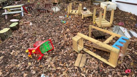 outdoor play area showing broken toys and equipment on the ground