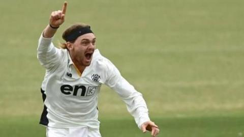 Corey Rocchiccioli screams with joy and points to the sky in celebration after taking a wicket for Western Australia