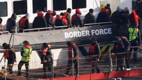 Migrants being brought to shore in Dover, Kent, from a Border Force vessel following a small boat incident in the Channel