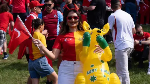 A fan in a half Turkey and Australia shirt with a blow-up wallaby