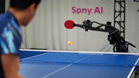 Sony AI autonomous robot Ace returns a shot in table tennis while its human opponent watches on