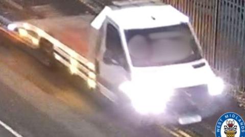 The image is of a blurred white van with its lights on. There is a West Midlands Police logo in the bottom right corner.