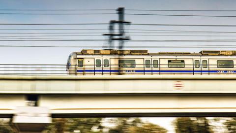 A speeding New Delhi Metro Train running on its elevated track.