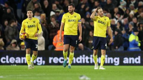 Ruben Rodrigues, Elliott Moore and Will Vaulks of Oxford United look dejected