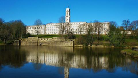 A white building overlooking a lake