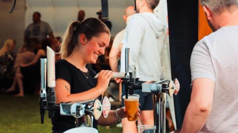 Woman pouring pint at the Bull I' Th' Thorn