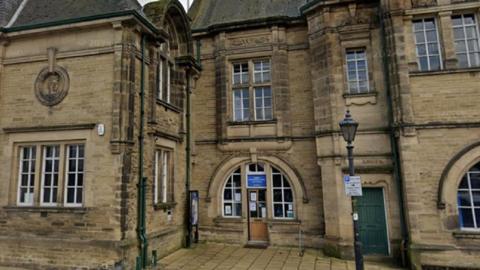 Victorian library building in brown stone with narrow windows