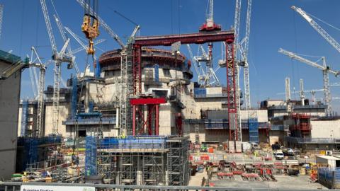 Cranes surround one of the cylindrical reactor buildings at Hinkley Point C