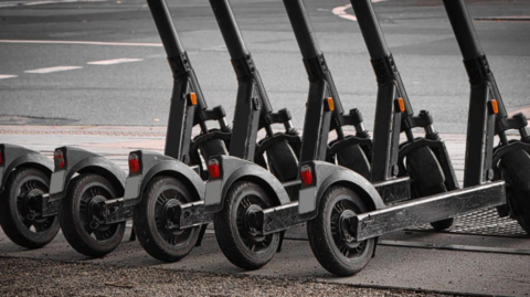 A row of parked e-scooters in a town centre