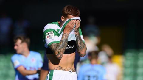 Yeovil Town player holds his shirt over his face after conceding a goal in the 98th minute against Gateshead