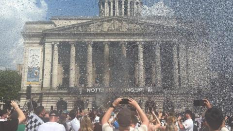 A sky filled with black and white confetti in front of the Nottingham Council house
