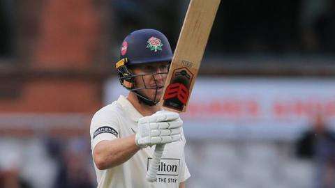 Luke Wells raises his bat to celebrate another 50 for Lancashire