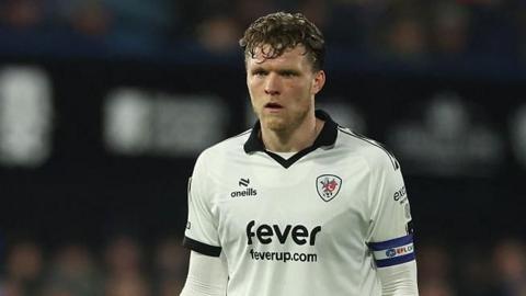 Rob Dickie standing on the pitch during a match wearing Bristol City away kit