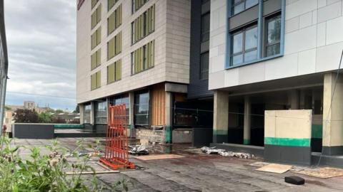The hotel building site with boarding on the ground.