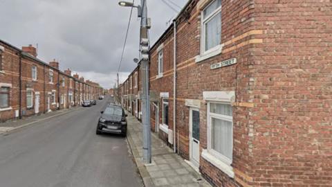 Fifth Street in Horden - a row of modest, old, brick terraced houses with front doors leading straight onto the pavement. There are several parked cars down the street.