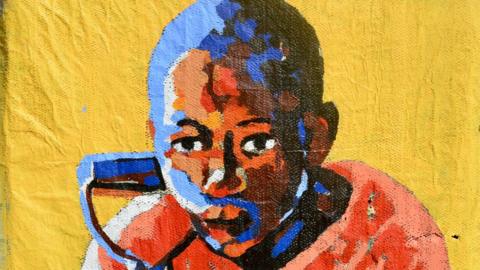 Title: Shofolo. Medium: Acrylic on perforated newspaper. Painting of a young boy in an orange T-shirt leaning over his shovel. The background is yellow.