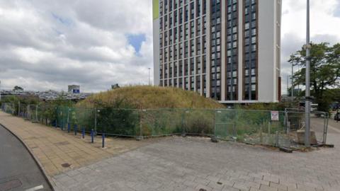 The site of the old Gala Bingo building at Fairfax Street in Coventry showing an empty site with a hill of earth just in front of a tower block