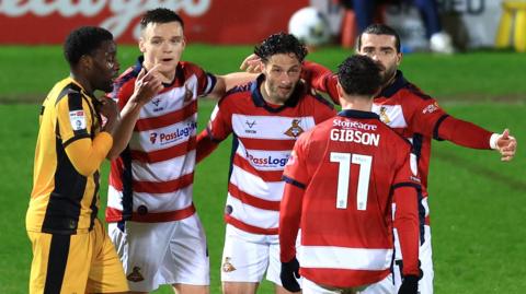 Doncaster Rovers players celebrate the winning goal against Port Vale